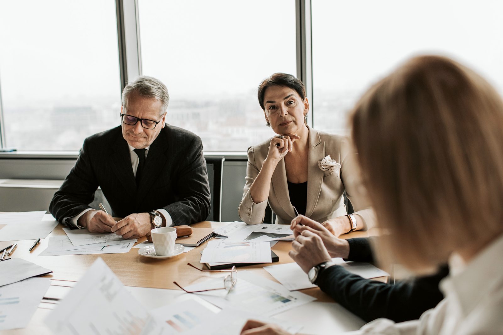 A negotiation at the table: two professionals examine the documents facing the other party